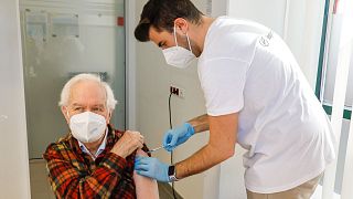FILE - The patient Kurt Switil, left, receives a Pfizer vaccination against the COVID-19 disease by a doctor in the vaccination centre in Vienna, Austria, April 2021.