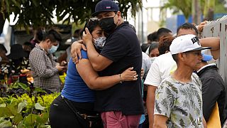 Des familles s’enlacent devant la morgue dans l'attente de nouvelles de leurs proches détenus au pénitencier de Guayaquil, en Équateur, dimanche 14 novembre 2021.