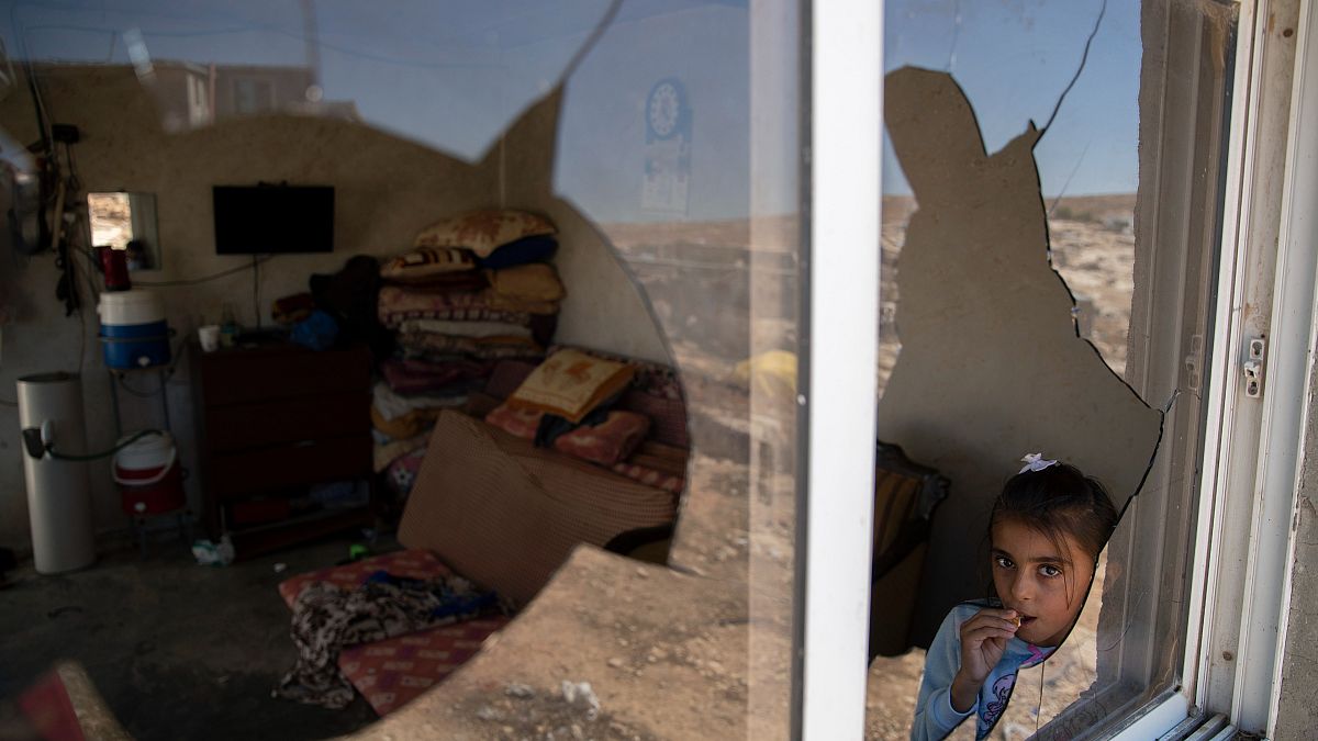فتاة فلسطينية تظهر من نافذة منزل عائلتها المحطمة جراء هجوم مستوطنين، في قرية المفجرة قرب الخليل. 2021/09/30