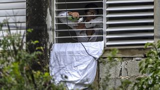 Yunior Garcia Aguilera protesta con una sábana blanca y rosas por su encierro en su vivenda