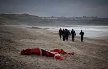 French police patrolling the beach between Ambleteusse and Wimereux, northern France, pass by the wreckage of asmall boat used by migrants, October 16, 2021.