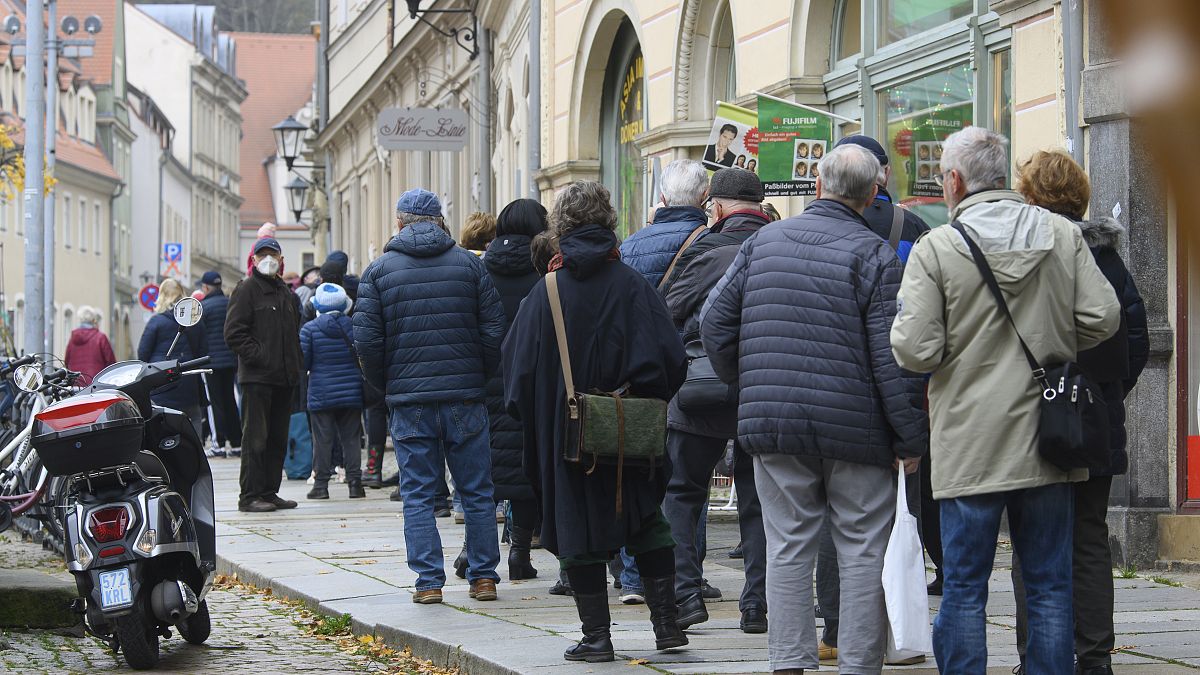 People wait in a long line to be vaccinated against the coronavirus during a vaccination campaign of the DRK, German Red Cross, in front of the town hall in Pirna, Germany.