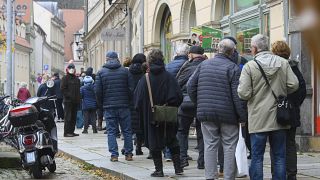 People wait in a long line to be vaccinated against the coronavirus during a vaccination campaign of the DRK, German Red Cross, in front of the town hall in Pirna, Germany.