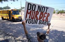 رجل يحمل لافتة مكتوب عليها " لا تقتل طفلك" أمام عيادة تقدم خدمات إجهاض في دالاس، تكساس.