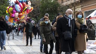 People make their way at a central market street in Athens, Sunday, Dec.19, 2021. 