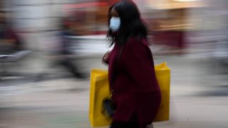 A shopper walks along Oxford Street, Europe's busiest shopping street, in London, Saturday, Dec. 18, 2021.