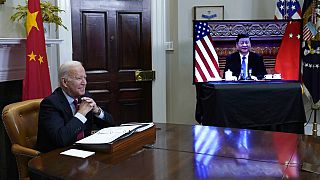 President Joe Biden, left, speaks as he meets virtually with Chinese President Xi Jinping, on screen
