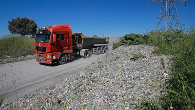 İstanbul'da Mayıs 2021'de çekilen bir fotoğraf. Bir kamyon çöp yükünü gelişigüzel bir şekilde yol kenarına bırakıyor.