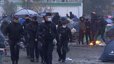 Police walking through camp near Grande-Synthe in northern France.