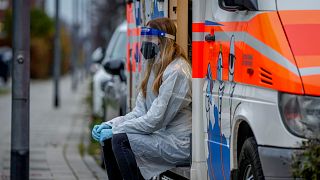 Almanya'nın Frankfurt kentinde bir seyyar Covid aracı içerisinde bir çocuğun test için hazırlanmasını bekleyen sağlık görevlisi