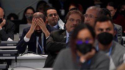 A delegate listens during the closing plenary session of COP26 in Glasgow on Sunday