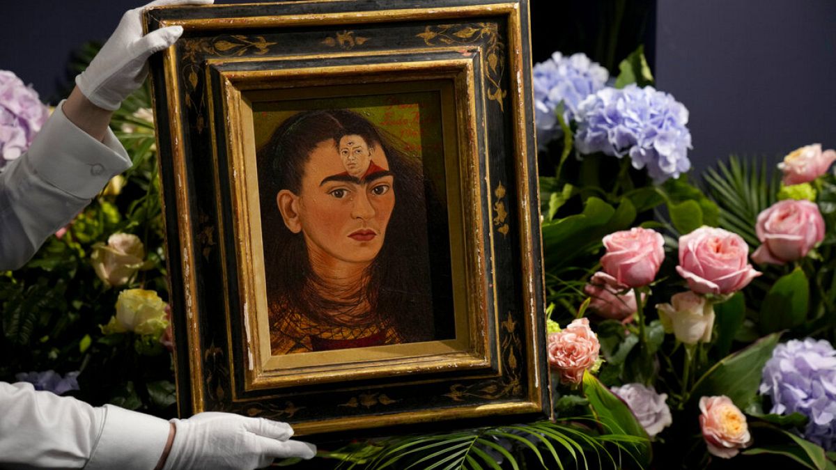 Un empleado sostiene el autorretrato de 1949 "Diego y yo", de la pintora mexicana Frida Kahlo, 21/10/2021, Londres, Reino Unido