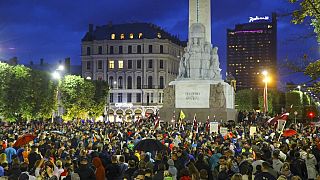 People gather around the Independence Stella monument at a protest against mandatory vaccinations in Riga, Latvia in August 2021