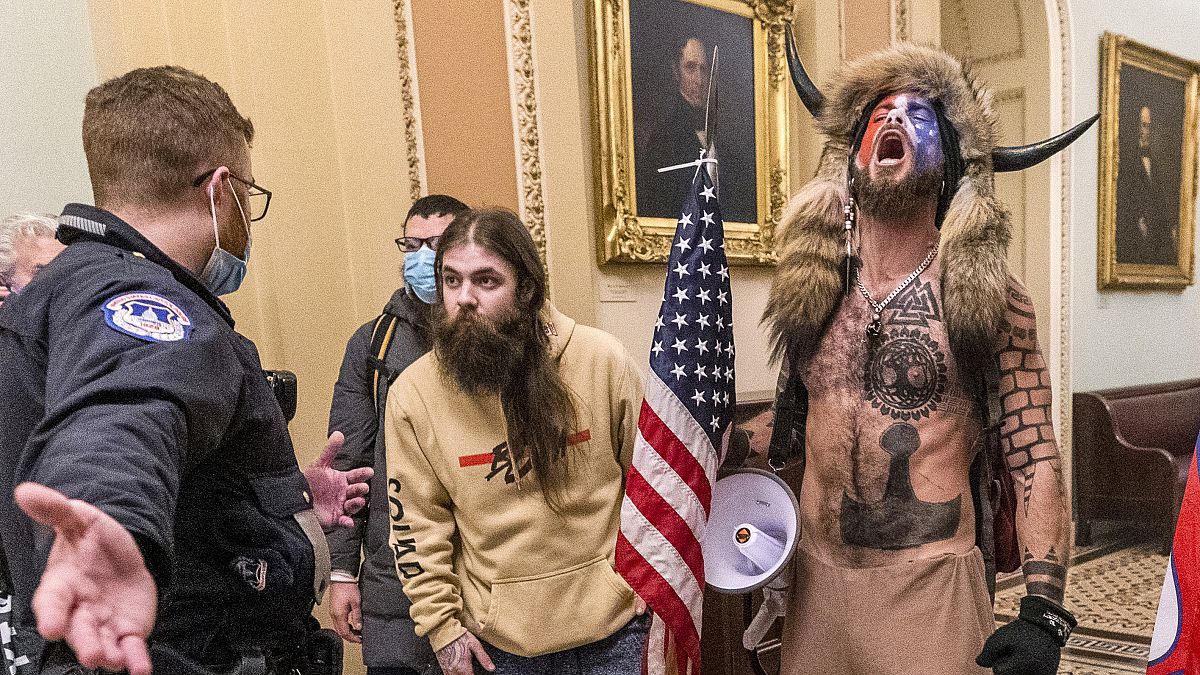Supporters of Donald Trump, including Jacob Chansley (R) with fur hat, are confronted by US Capitol Police officers outside the Senate chamber, Washington DC, January 6, 2021.