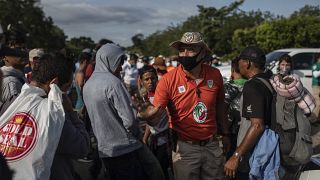 Un funcionario de migración mexicano intenta persuadir a los migrantes para que no sigan caminando hacia el norte, 16/11/2021, Jesús Carranza, México