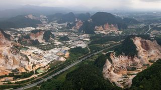 Deforestation surrounds massive limestone quarries cut into the mountains of Ipoh in Malaysia.