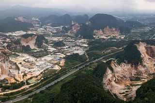Deforestation surrounds massive limestone quarries cut into the mountains of Ipoh in Malaysia.