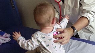 A physiotherapist examines a 9-month-old baby affected by bronchiolitis in 2003.