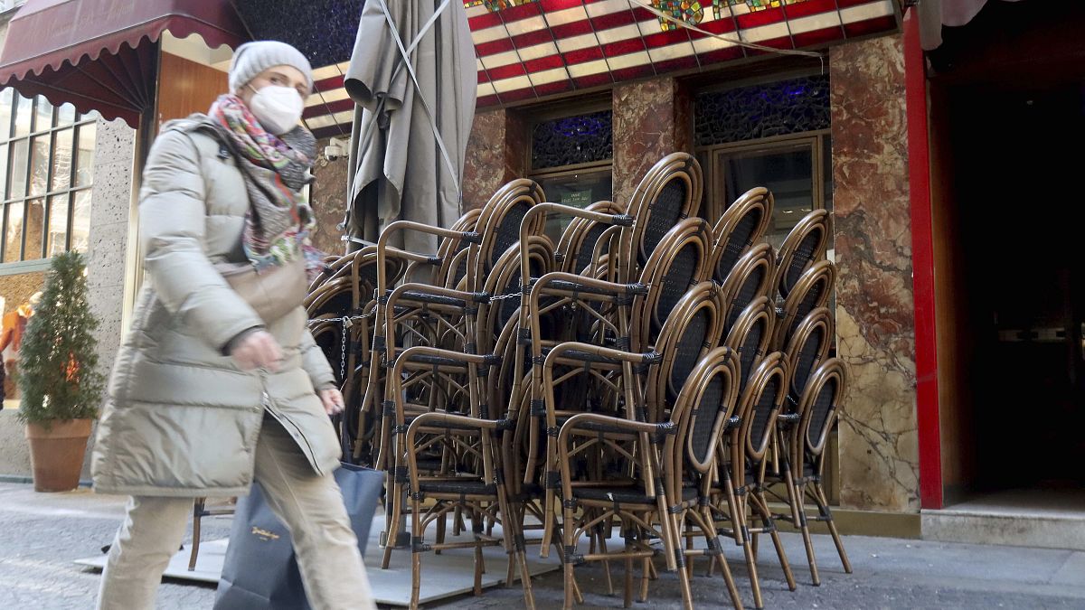 Una mujer camina por delante de un bar cerrado en el centro de Viena, Austria, el 15 de febrero de 2021. (ARCHIVO)