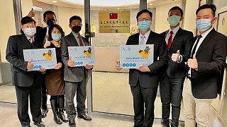 In this photo released by the Taiwan Ministry of Foreign Affairs, staff pose outside the Taiwan Representative Office in Vilinius, Lithuania on Thursday, Nov. 18, 2021.