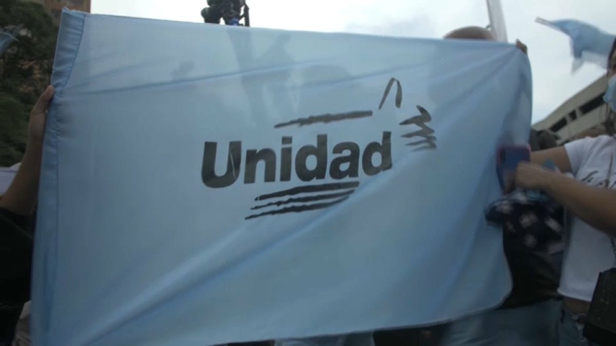 Partidarios de la oposición venezolana ondean una bandera con el lema "Unidad"