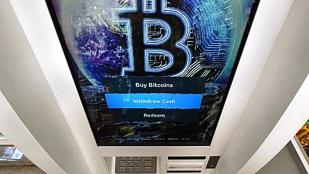 Bitcoin logo appears on the display screen of a cryptocurrency ATM at the Smoker's Choice store in Salem, N.H.