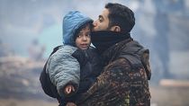 رجل يقبل ابنه عند حدود بيلاروس-بولندا