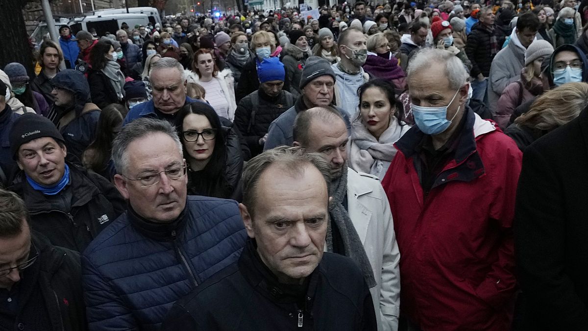 Former European Union leader Donald Tusk, foreground, now leader of Poland's opposition, takes part in a massive protest in Warsaw, Poland, Saturday, Nov. 6, 2021,