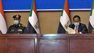 الجنرال السوداني عبد الفتاح البرهان ورئيس الوزراء عبد الله حمدوك خلال مراسم توقيع اتفاق لإعادة انتقال السلطة إلى المدنيين.