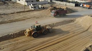 العمال والجرافات والآليات الثقيلة في مواقع البناء في قطاع غزة الذي دمرته الحرب.