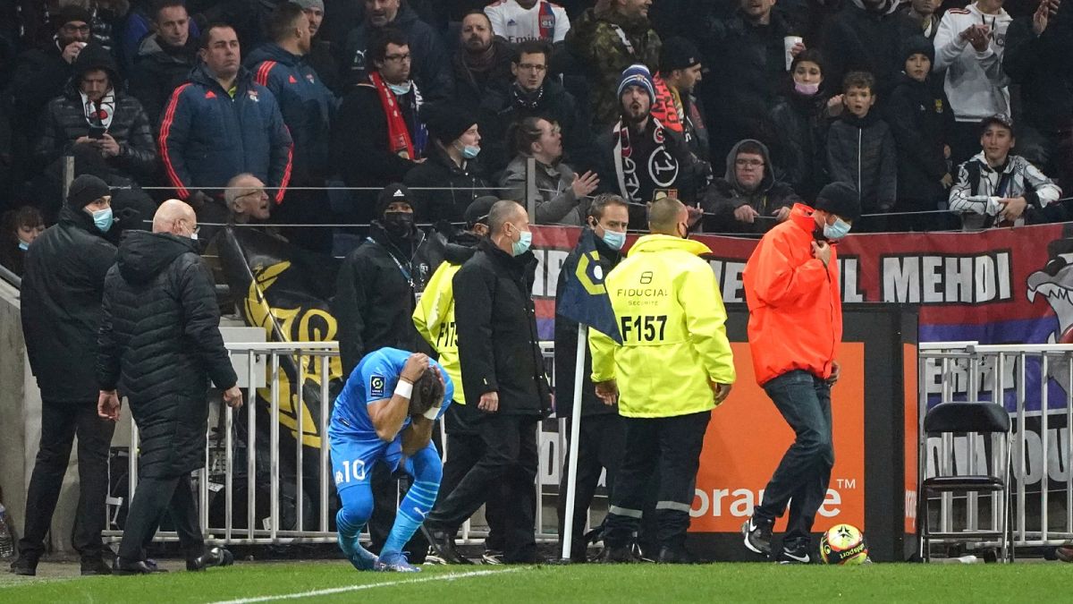 Marseille's Dimitri Payet reacts after being injured by an object thrown by a Lyon supporter 