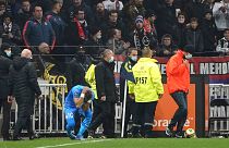 Marseille's Dimitri Payet reacts after being injured by an object thrown by a Lyon supporter