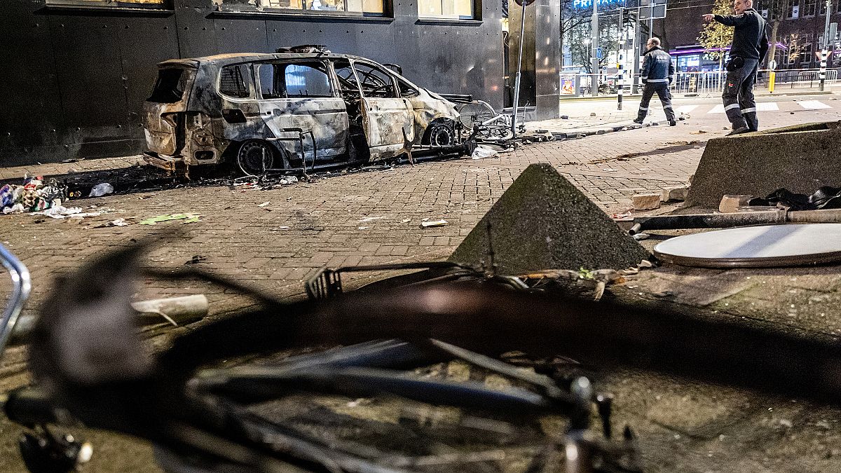 This photograph taken on November 20, 2021 shows a burned car after a protest against the partial lockdown and against the 2G government policy in Rotterdam