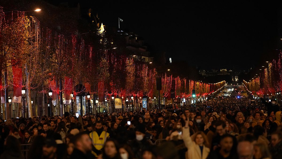 Spectators gather to attend the Champs Elysee Avenue illumination ceremony for the Christmas season, in Paris, Sunday, Nov. 21, 2021.
