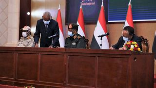 عبد الله حمدوك الذي أطيح به في انقلاب الشهر الماضي، يجلس إلى جانب اللواء عبد الفتاح البرهان، لتوقيع اتفاق يعيده رئيسا للوزراء، بالخرطوم، السودان، الأحد 21 نوفمبر 2021