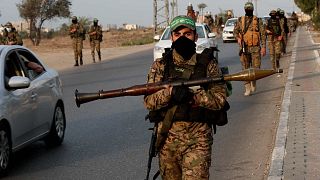 مسلحون من كتائب عز الدين القسام، الجناح العسكري لحركة حماس، يسيرون ببنادقهم على طول الطريق الرئيسي لمخيم النصيرات وسط قطاع غزة، الخميس 28 تشرين الأول (أكتوبر) 2021