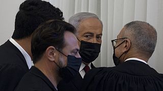 Former Israeli Prime Minister Benjamin Netanyahu, third from left, is flanked by lawyers before testimony by star witness Nir Hefetz, a former aide, in his corruption trial at