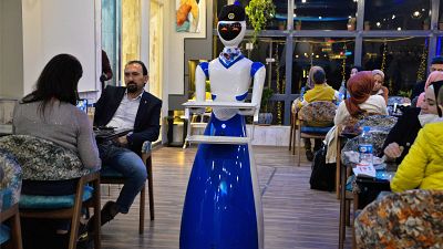 A robot waiter carries empty trays after delivering an order to patrons at the "White Fox" restaurant in the eastern part of Iraq's northern city of Mosul.