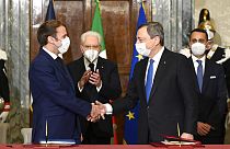 France's President Emmanuel Macron, left, and Italy's Prime Minister Mario Draghi shake hands at the Quirinale presidential palace in Rome, Friday, Nov. 26, 2021.