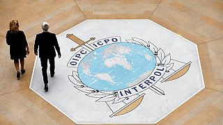 Foto aus dem Jahr 2018: Zwei Personen laufen über den Teppich im Hauptsitz von Interpol in Lyon, Frankreich.