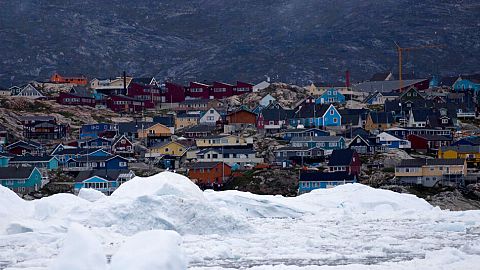 floating ice, left over from broken-up icebergs shed from the Greenland ice sheet, nearly cover the seafront in Ilulissat, Greenland.