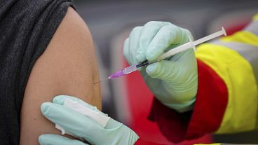 A person is vaccinated with the Pfizer vaccine against the coronavirus and the COVID-19 disease at vaccination bus in Berlin, Germany, Tuesday, Nov. 23, 2021. 