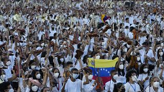 Members of the National Orchestra System raise their instruments after they played a 12-minute Piotr's Slavic March Ilich Tchaikovsky in Caracas, Venezuela, on Nov. 13, 2021.