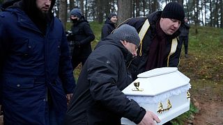 امام جماعت لهستانی در حال دفن نوزاد به دنیا نیامده عراقی