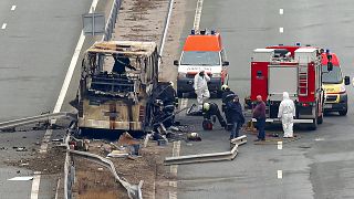 Firefighters and forensic workers inspect the scene of a bus crash on a highway near the village of Bosnek, western Bulgaria, Tuesday, Nov. 23, 2021
