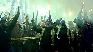 Coal miners hold flares as they gather during protest near government building in Sarajevo, on November 23, 2021.