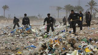 عمال ينظفون الشاطئ من القمامة شمال بيروت، لبنان.