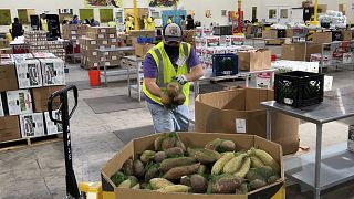 عامل يضع أكياس البطاطا الحلوة في مستودع بنك الطعام المجتمعي في أوكلاند، كاليفورنيا.
