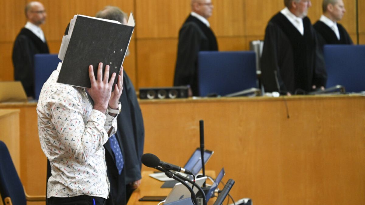 FILE: At the opening of the trial, defendant Taha Al-J. covers his face with a folder in Frankfurt, Germany, Friday, April 24, 2020.
