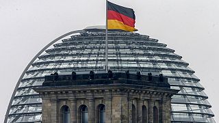 Una bandera alemana ondea sobre el edificio del Reichstag en Berlín, Alemania.